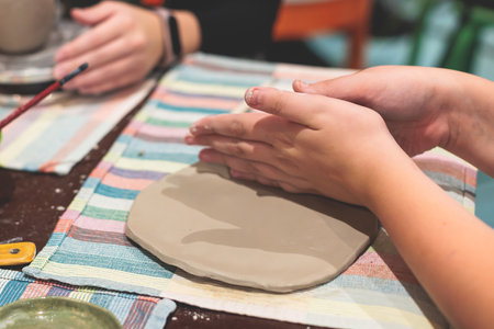 Pottery lesson master class for kids children, process of making clay pot on pottery wheel, potter...