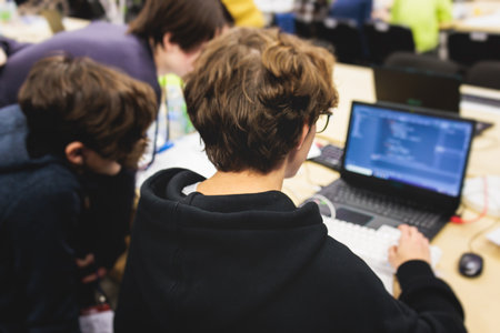 Software developer students in auditorium hall working on computer and laptop, programming contest...