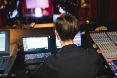 View of lighting technician operator working on mixing console workplace during live event concert on stage show broadcast, light mixer controller panel, sound technician with professional equipmentの写真素材