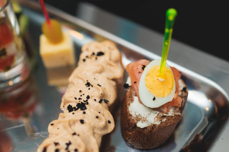 Beautifully decorated banquet catering table, with variety of with different food snacks appetizers on corporate birthday party event or wedding celebration, canape, salad, delicatessen settingの写真素材