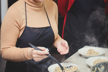 Group of people in a cooking class studio, adults preparing different dishes in the kitchen together, people in aprons learn on culinary master class, chef uniform, hands in gloves, Italian cuisineの写真素材