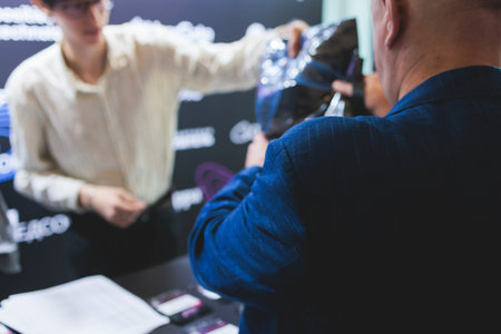Process of checking in on a conference congress forum event, registration desk table, visitors and attendees receiving a name badge and entrance wristband bracelet and register electronic ticketの写真素材