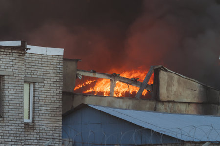 Massive large blaze fire in the city, blazing warehouse factory, storage building burning,...