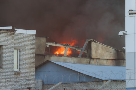 Massive large blaze fire in the city, blazing warehouse factory, storage building burning,...