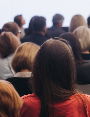 Female audience at the symposium meeting, participants in conference room hall listens to lecturer,...