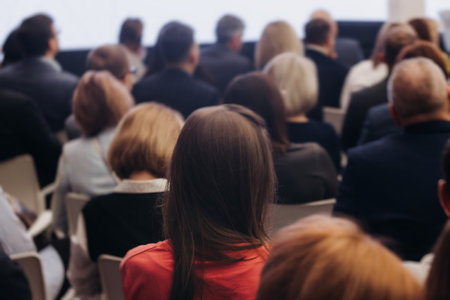 Female audience at the symposium meeting, participants in conference room hall listens to lecturer, group of women on a congress together listen to speaker on a stage at master-classの写真素材
