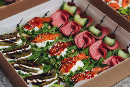 Catering table, beautifully decorated banquet with variety of different food snacks appetizers on Christmas birthday corporate party event or wedding celebration, canape, salad, delicatessen settingの写真素材