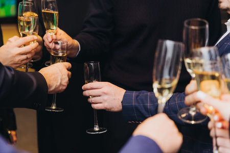 Group of businessmen celebrate, closing successful completed deal, guests clinking raise glasses with alcohol, sparkling wine, toasting and cheering, colleagues team in office on corporate party eventの写真素材