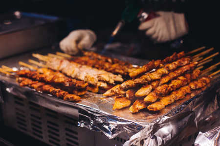 Korean barbecue, Ddakkochi, grilled chicken and pork skewers, variety of different traditional street food selection in Seoul, South Korea, market with local vendor stalls cooking tasty dishesの写真素材