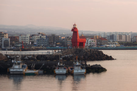 Iho Tewoo Horse Lighthouses on Iho Tewoo beach, with two horse-shaped lighthouses, white horse lighthouse and red horse lighthouse, Jeju-do, Jeju island, Jeju-si, South Korea, sunny sunsetの写真素材