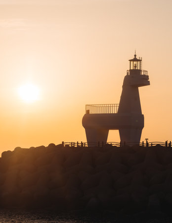 Iho Tewoo Horse Lighthouses on Iho Tewoo beach, with two horse-shaped lighthouses, white horse lighthouse and red horse lighthouse, Jeju-do, Jeju island, Jeju-si, South Korea, sunny sunsetの写真素材