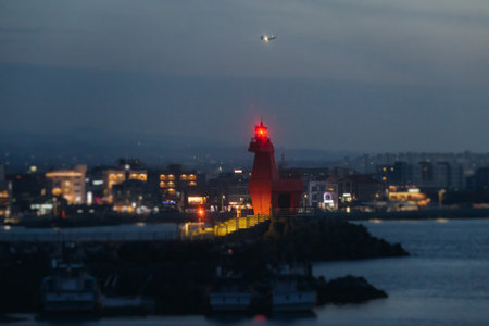 Iho Tewoo Horse Lighthouse on Iho Tewoo beach, with a horse-shaped lighthouse, red horse lighthouse, Jeju-do, Jeju island, Jeju-si, South Korea, sunsetの写真素材