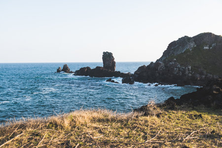 Jeju-do, Seopjikoji cape landscape with lighthouse and sea, east coast of Jeju Island, South Korea, Seongsan-ri, Seogwipo, Jeju Province view in a sunny day, with sea and cliffsの写真素材