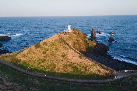 Jeju-do, Seopjikoji cape landscape with lighthouse and sea, east coast of Jeju Island, South Korea, Seongsan-ri, Seogwipo, Jeju Province view in a sunny day, with sea and cliffsの写真素材