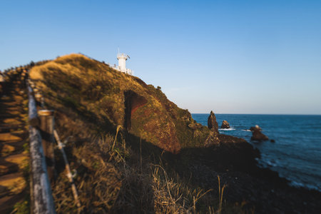 Jeju-do, Seopjikoji cape landscape with lighthouse and sea, east coast of Jeju Island, South Korea,...