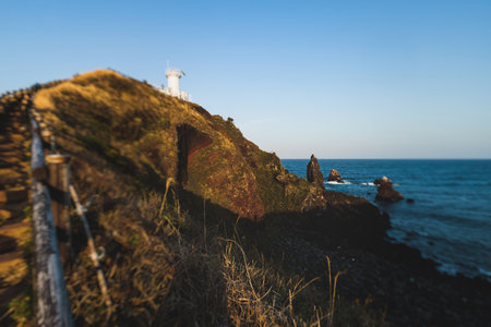 Jeju-do, Seopjikoji cape landscape with lighthouse and sea, east coast of Jeju Island, South Korea, Seongsan-ri, Seogwipo, Jeju Province view in a sunny day, with sea and cliffsの写真素材
