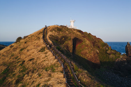 Jeju-do, Seopjikoji cape landscape with lighthouse and sea, east coast of Jeju Island, South Korea, Seongsan-ri, Seogwipo, Jeju Province view in a sunny day, with sea and cliffsの写真素材