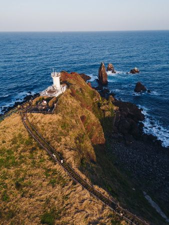 Jeju-do, Seopjikoji cape landscape with lighthouse and sea, east coast of Jeju Island, South Korea, Seongsan-ri, Seogwipo, Jeju Province view in a sunny day, with sea and cliffsの写真素材