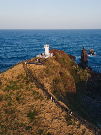 Jeju-do, Seopjikoji cape landscape with lighthouse and sea, east coast of Jeju Island, South Korea, Seongsan-ri, Seogwipo, Jeju Province view in a sunny day, with sea and cliffsの写真素材