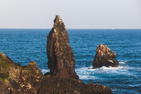 Jeju-do, Seopjikoji cape landscape with lighthouse and sea, east coast of Jeju Island, South Korea, Seongsan-ri, Seogwipo, Jeju Province view in a sunny day, with sea and cliffsの写真素材
