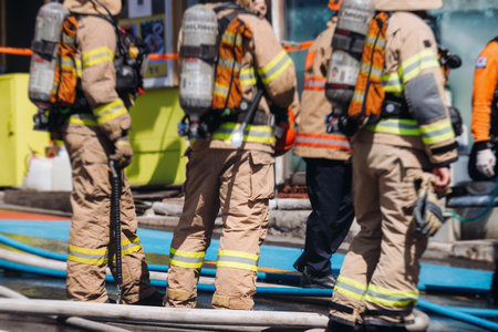 Group of South Korean fire men during fire fighting operation in the streets, firefighters with fire engine truck vehicle, 911 emergency and rescue, fire drill, exercise training, Busan, South Koreaの写真素材