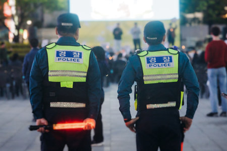 Korean police squad formation in uniform with "Police" logo, policemen officer patrol maintain public order during political demonstration protest rally in the streets of Busan center, South Koreaの写真素材