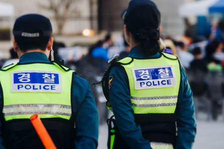 Korean police squad formation in uniform with "Police" logo, policemen officer patrol maintain public order during political demonstration protest rally in the streets of Busan center, South Koreaの写真素材