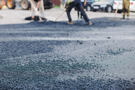 Roadworks, process of asphalting, blacktopping and paving new road layer, laying new asphalt road pavement, paver machine and steam roller compactor, city street construction site, vehicle workingの写真素材