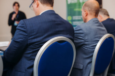 Audience at the modern conference hall listens to panel discussion, people on a congress together listen to speaker on stage at convention, plenary session at business seminar, venue for presentationの写真素材