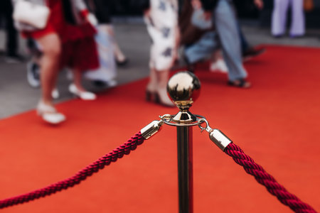 Red carpet with ropes and golden barriers on a luxury party entrance, cinema premiere film festival event award gala ceremony, wealthy rich guests arriving, outdoor decoration elements, summer dayの写真素材
