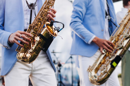 Concert view of saxophonist musician, saxophone sax player with vocalist and musical band during jazz orchestra show performing music on a stage in the scene lights, concert in a musical club hallの写真素材