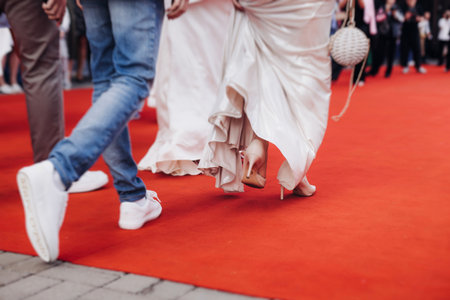 Red carpet with ropes and golden barriers on a luxury party entrance, cinema premiere film festival event award gala ceremony, wealthy rich guests arriving, outdoor decoration elements, summer dayの写真素材
