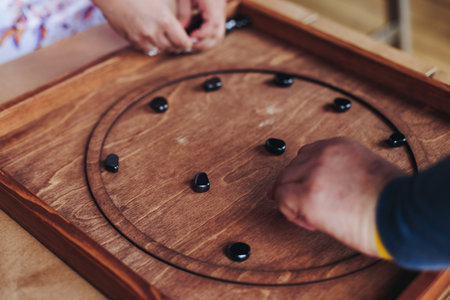 Process of playing tabletop board game on the table, fun with friends and family in room indoors, board game party concept, company group of students adults play board games, roll the dice on game mapの写真素材