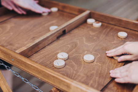 Process of playing tabletop board game on the table, fun with friends and family in room indoors, board game party concept, company group of students adults play board games, roll the dice on game mapの写真素材