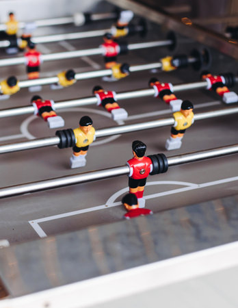 Group of friends playing kicker in a sports bar room, colleagues playing table football, table...