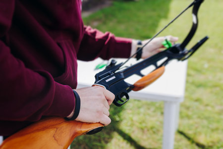 Crossbow shooting and archery at the shooting range, women and men practicing with arbalest at shooting gallery, compound bow training, aiming the target with arbalest at archery range, bow and arrowsの写真素材