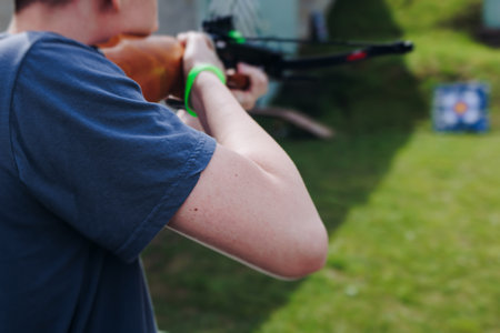 Crossbow shooting and archery at the shooting range, women and men practicing with arbalest at shooting gallery, compound bow training, aiming the target with arbalest at archery range, bow and arrowsの写真素材
