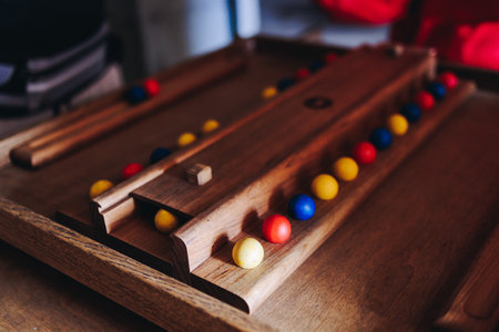 Process of playing tabletop board game on the table, fun with friends and family in room indoors,...
