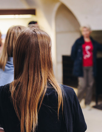 Group of students and tourists in a science museum exhibition, excursion tour with guide, a docent...