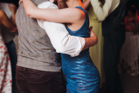 Couples dancing traditional latin argentinian dance milonga in a ballroom, tango salsa bachata kizomba lesson in red and purple lights, performance rehearsal, evening dance school class festivalの写真素材