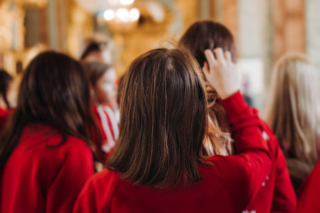Group of kids children on excursion in a museum gallery, school pupils and students tour with guide, a docent with a tourists, young visitors wearing red, school field trip, art exhibitionの写真素材