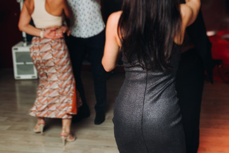 Couples dancing traditional latin argentinian dance milonga in a ballroom, tango salsa bachata lesson in red and purple lights, performance rehearsal, evening dance class festivalの写真素材