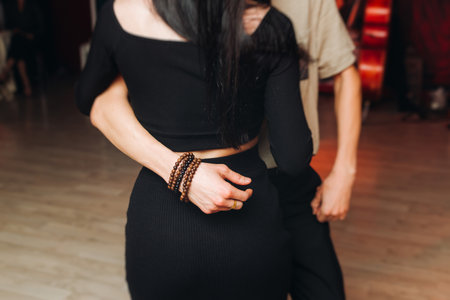 Couples dancing traditional latin argentinian dance milonga in a ballroom, tango salsa bachata lesson in red and purple lights, performance rehearsal, evening dance school class festivalの写真素材