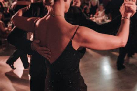 Couples dancing traditional latin argentinian dance milonga in a ballroom, tango salsa bachata kizomba lesson in red and purple lights, performance rehearsal, evening dance school class festivalの写真素材