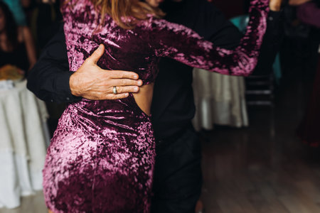 Couples dancing traditional latin argentinian dance milonga in a ballroom, tango salsa bachata kizomba lesson in red and purple lights, performance rehearsal, evening dance school class festivalの写真素材