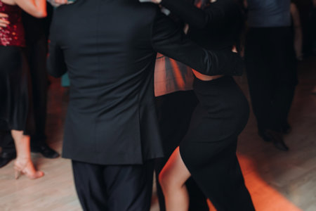 Couples dancing traditional latin argentinian dance milonga in a ballroom, tango salsa bachata kizomba lesson in red and purple lights, performance rehearsal, evening dance school class festivalの写真素材