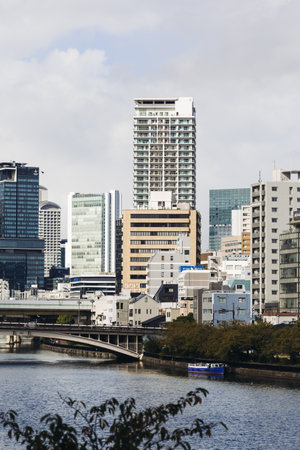 View of Osaka cityscape with Yodo River embankment and skyscrapers, Osaka prefecture, Japan, in a sunny day with a blue sky, streets of Osaka downtown center, travel to Japanの写真素材