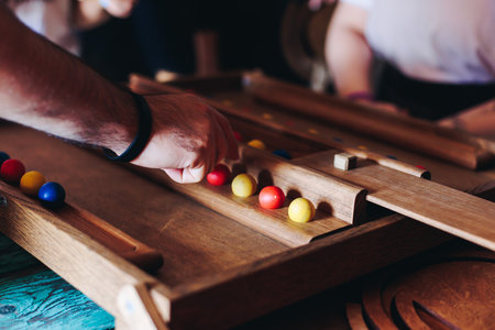 Process of playing tabletop board game on the table, fun with friends and family in room indoors, board game party concept, company group of students adults play board games, roll the dice on game mapの写真素材