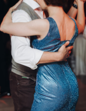 Couples dancing traditional latin argentinian dance milonga in a ballroom, tango salsa bachata kizomba lesson in red and purple lights, performance rehearsal, evening dance school class festivalの写真素材