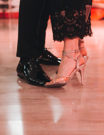Dancing stiletto shoes of couples dancing traditional latin argentinian dance milonga in the ballroom, tango salsa bachata kizomba lesson in red and purple lights, evening dance school class festivalの写真素材